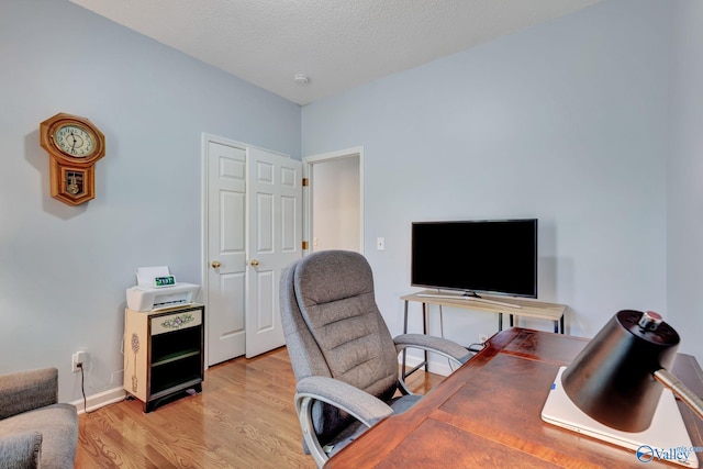 office featuring light hardwood / wood-style floors and a textured ceiling