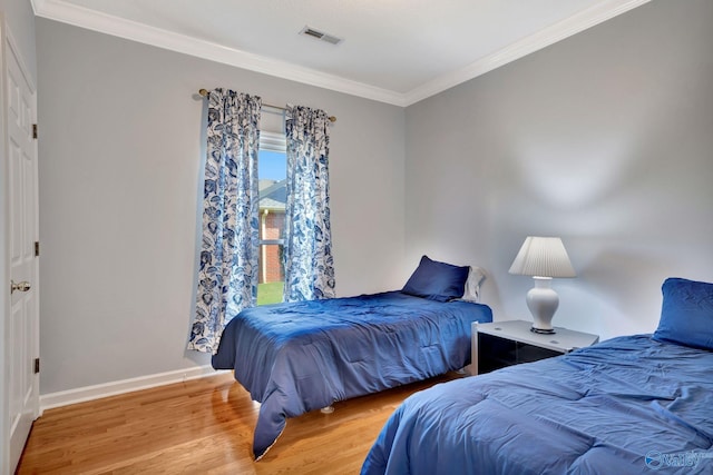 bedroom with hardwood / wood-style floors and crown molding