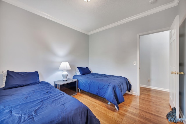 bedroom featuring hardwood / wood-style flooring, crown molding, and a textured ceiling