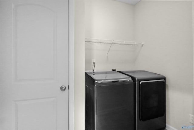 laundry room featuring separate washer and dryer, laundry area, and baseboards
