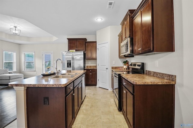 kitchen featuring a sink, a center island with sink, visible vents, appliances with stainless steel finishes, and open floor plan