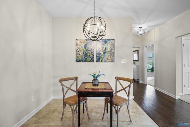 dining area with wood finished floors, a chandelier, and baseboards