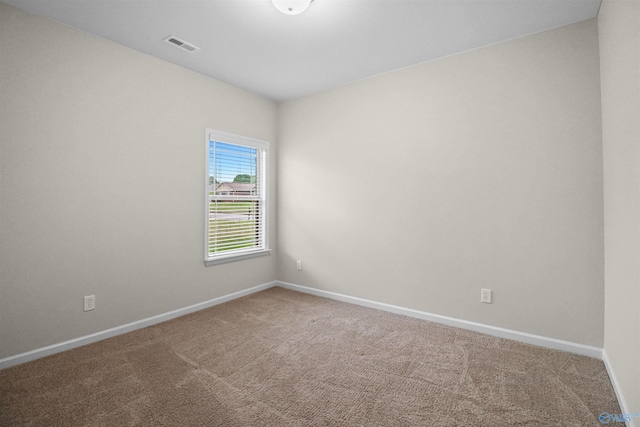 carpeted spare room with baseboards and visible vents