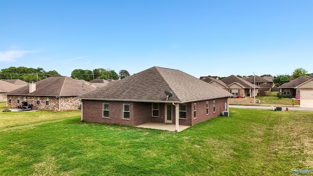 rear view of house featuring roof with shingles, central AC unit, a yard, and a patio area