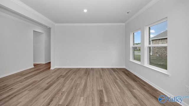 unfurnished room featuring crown molding, baseboards, and wood finished floors