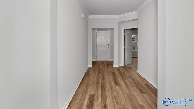 hallway with crown molding, wood finished floors, and baseboards