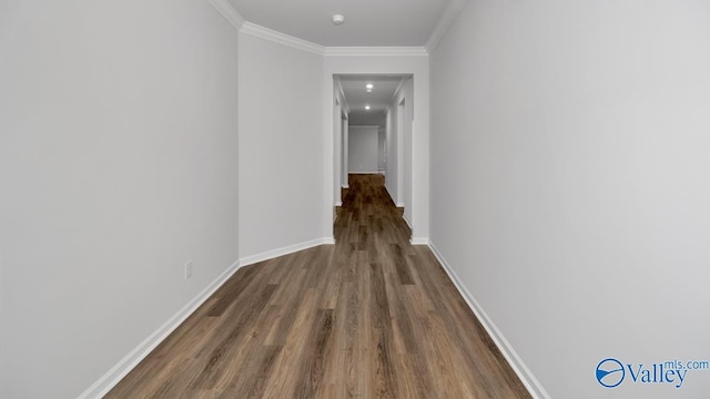 hall featuring crown molding, baseboards, and wood finished floors