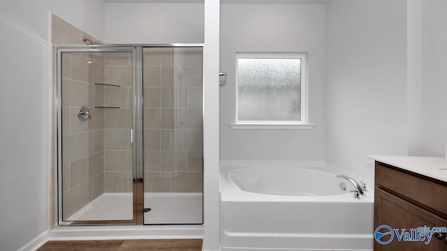 bathroom featuring a stall shower, vanity, and a bath