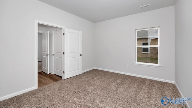 carpeted spare room with baseboards and visible vents