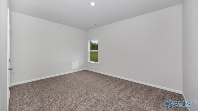 carpeted empty room featuring baseboards