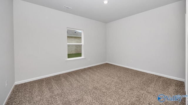 unfurnished room featuring carpet, visible vents, and baseboards