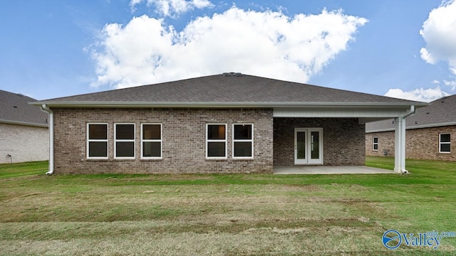 back of house with a yard, a patio area, brick siding, and french doors