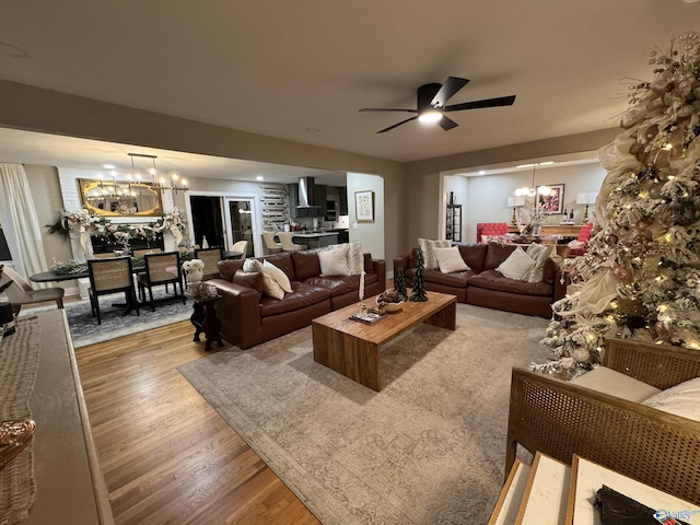 living room with hardwood / wood-style floors and ceiling fan with notable chandelier