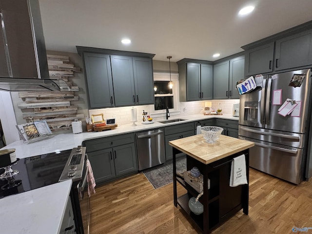 kitchen with pendant lighting, stainless steel appliances, dark wood-type flooring, and sink