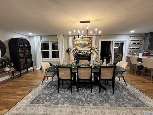 dining area with dark hardwood / wood-style flooring and an inviting chandelier