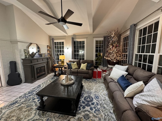 living room featuring a fireplace, high vaulted ceiling, ceiling fan, and light tile patterned flooring