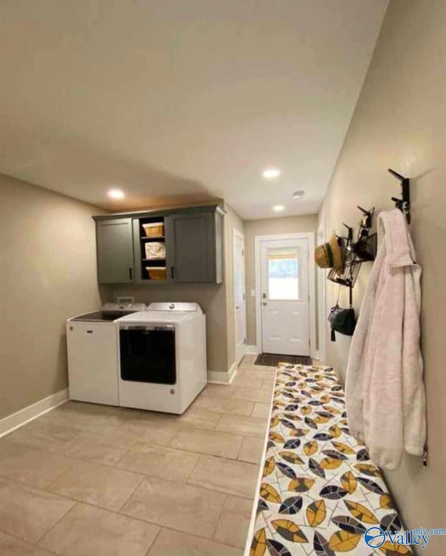 kitchen with light tile patterned floors, washing machine and dryer, and gray cabinets