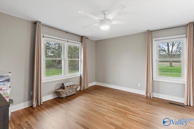 empty room with hardwood / wood-style floors and ceiling fan