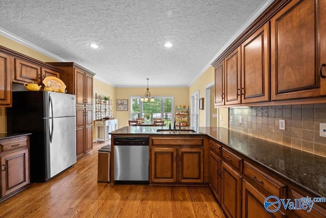 219 Sharp Dr, Gadsden, AL 35903 - kitchen with stainless steel appliances, a sink, wood finished floors, a peninsula, and a textured ceiling