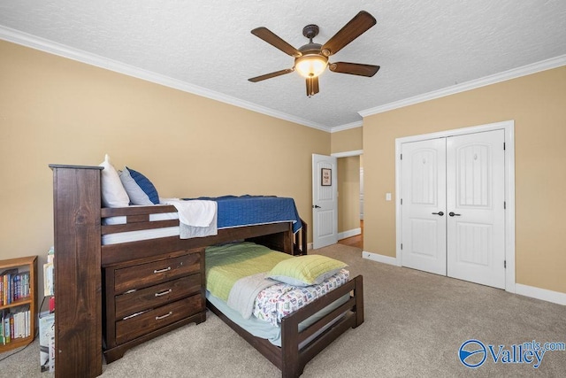219 Sharp Dr, Gadsden, AL 35903 - bedroom with a textured ceiling, crown molding, a closet, light carpet, and baseboards