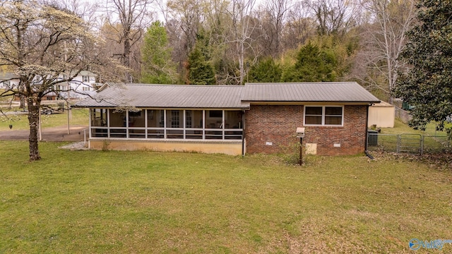 view of front facade featuring a front yard, brick siding, metal roof, a sunroom, and crawl space