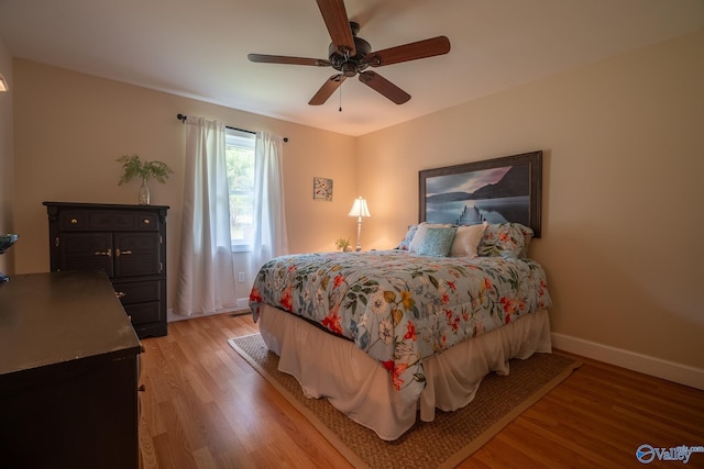 bedroom with baseboards, light wood-style floors, and ceiling fan