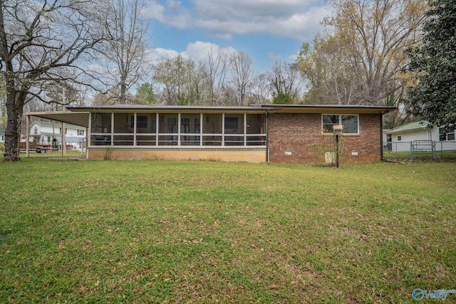 back of house featuring a lawn, a sunroom, and fence