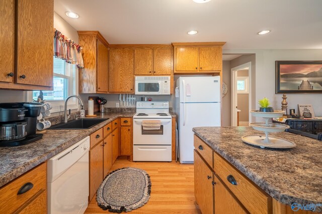 kitchen with white appliances, recessed lighting, a sink, light wood-type flooring, and brown cabinetry