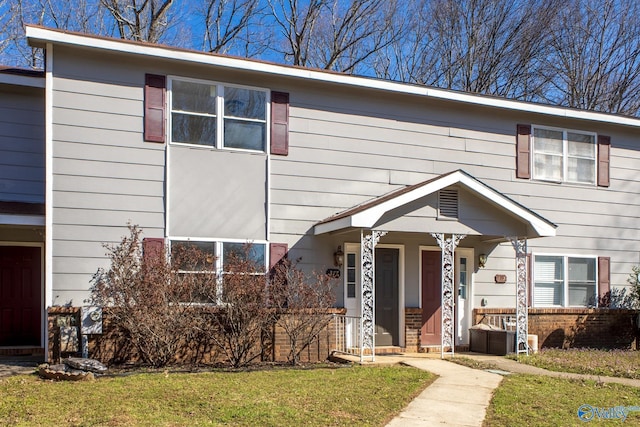 townhome / multi-family property featuring a front lawn