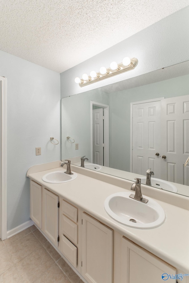 full bath with tile patterned floors, a textured ceiling, and a sink