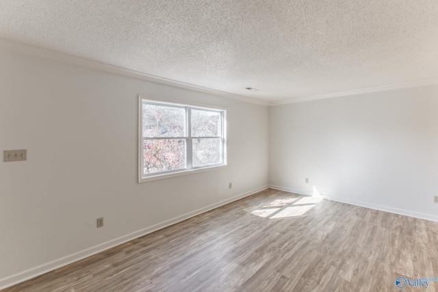 unfurnished room with baseboards, a textured ceiling, wood finished floors, and ornamental molding