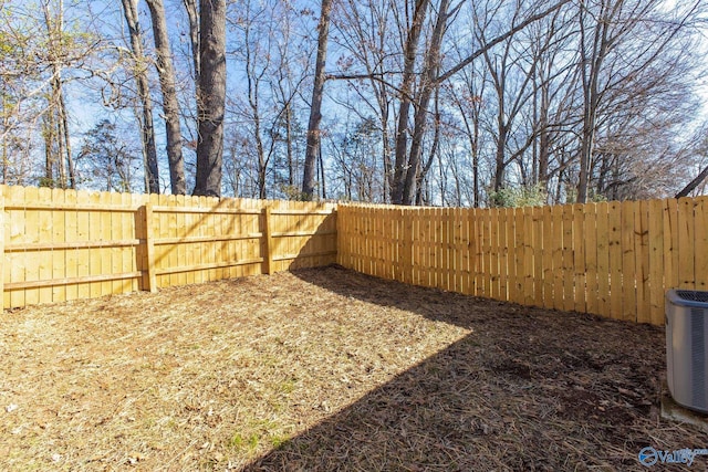 view of yard with central AC and a fenced backyard