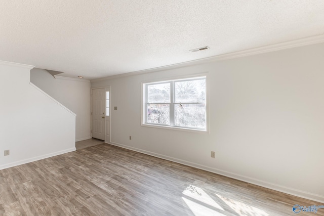 unfurnished living room with visible vents, a textured ceiling, crown molding, and wood finished floors