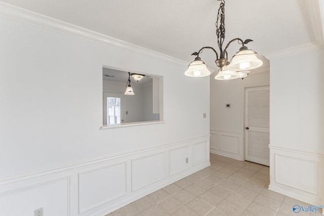 spare room with light tile patterned floors, a wainscoted wall, crown molding, and a decorative wall