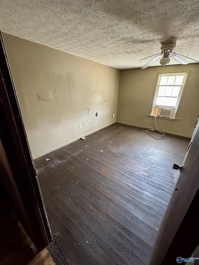 unfurnished room featuring cooling unit, a textured ceiling, dark wood-type flooring, and ceiling fan