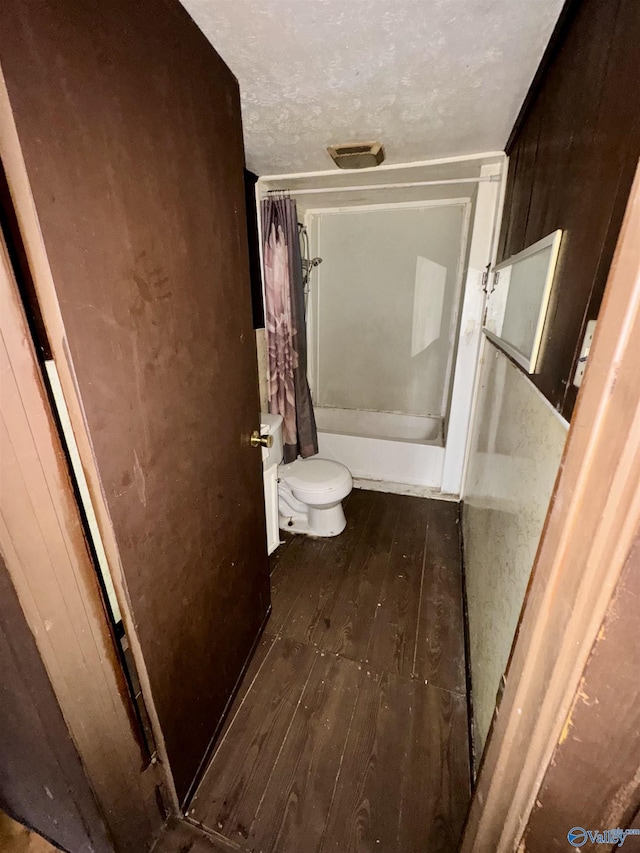 bathroom featuring shower / tub combo with curtain, wood-type flooring, a textured ceiling, toilet, and wood walls