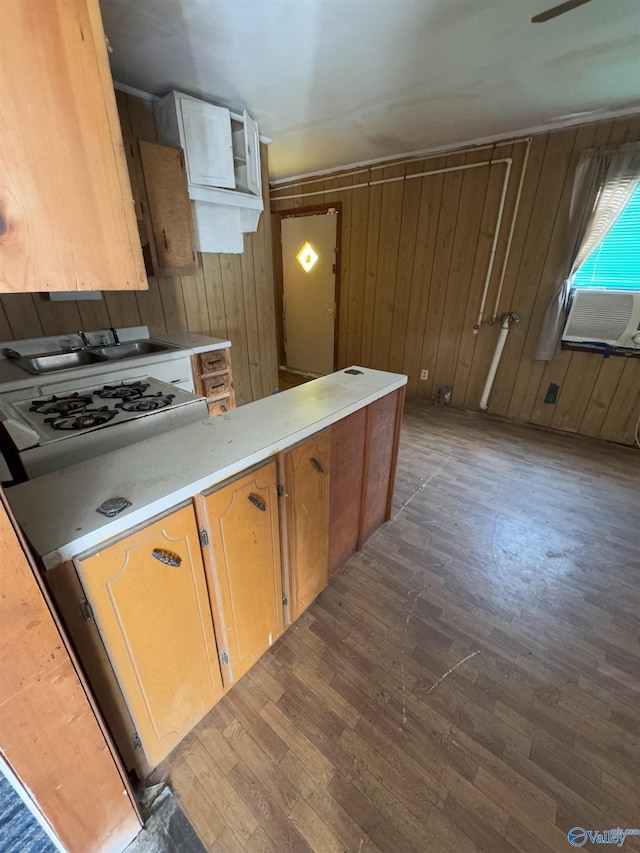 kitchen featuring white gas stovetop, wood walls, sink, cooling unit, and dark wood-type flooring