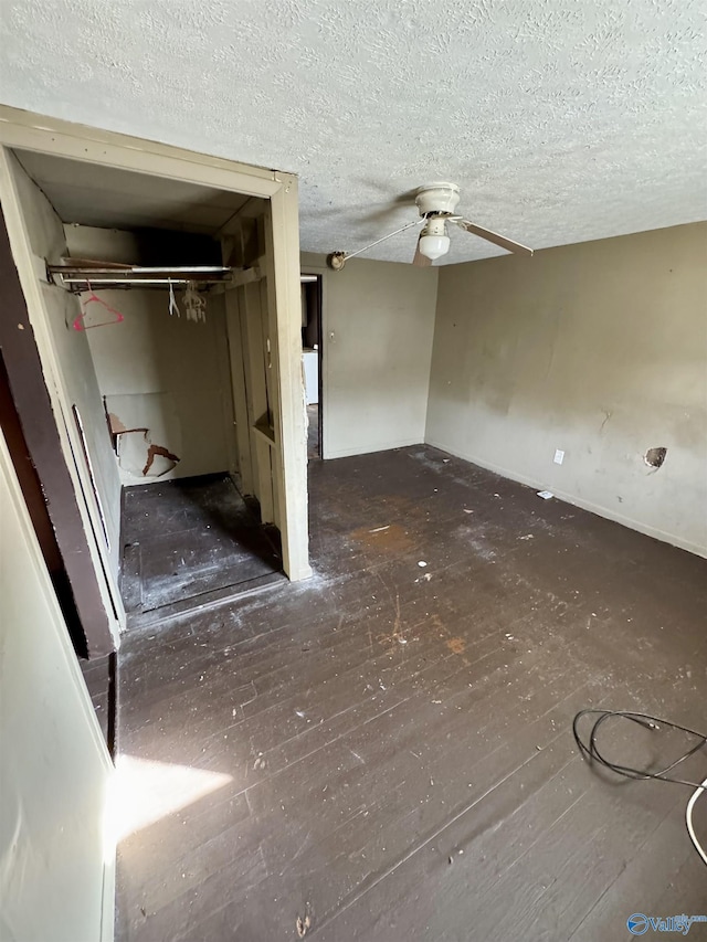 interior space featuring ceiling fan, dark hardwood / wood-style floors, and a textured ceiling