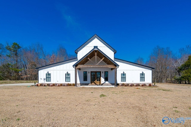 view of front of home featuring french doors, board and batten siding, and a front yard