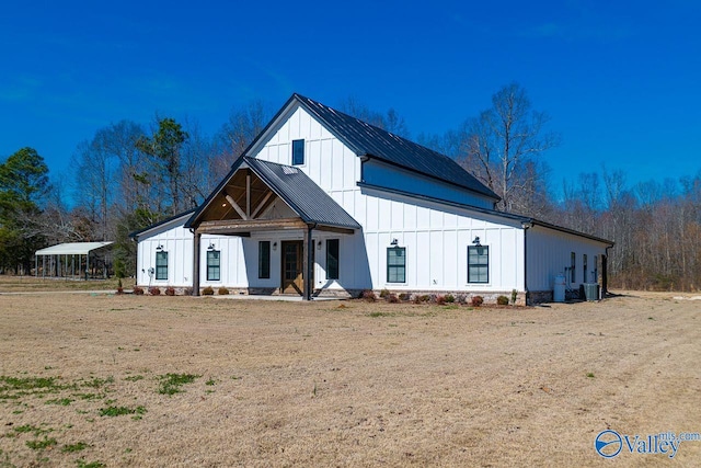 modern farmhouse featuring metal roof, board and batten siding, and a front yard