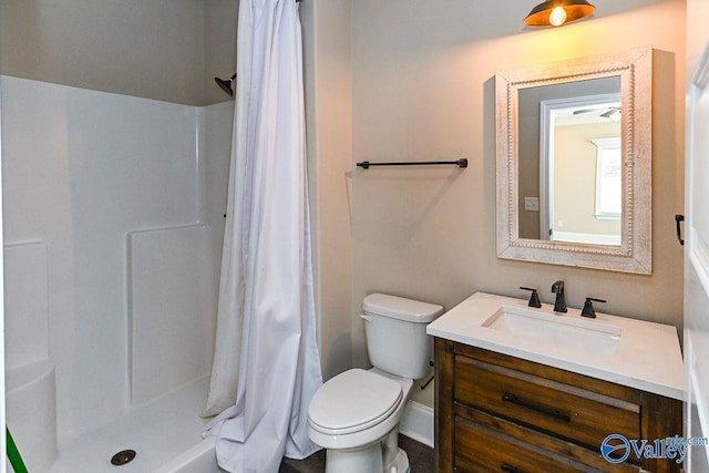 bathroom with toilet, a shower stall, and vanity