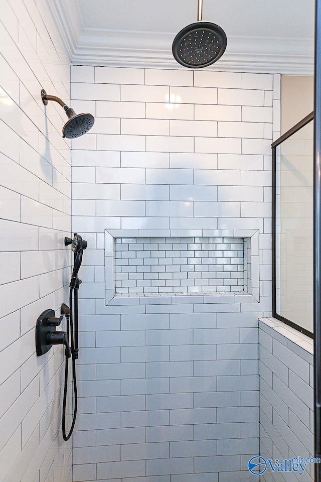 full bathroom featuring a tile shower and crown molding