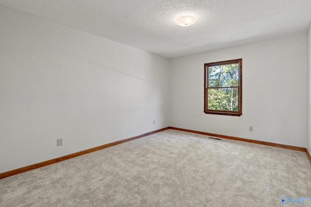 carpeted empty room with a textured ceiling