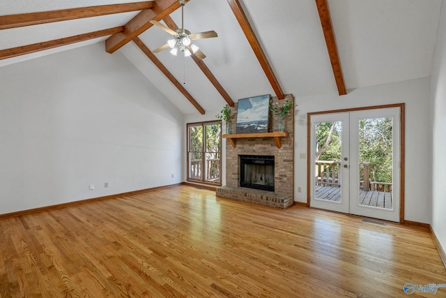 unfurnished living room with a fireplace, french doors, light wood-type flooring, and a wealth of natural light