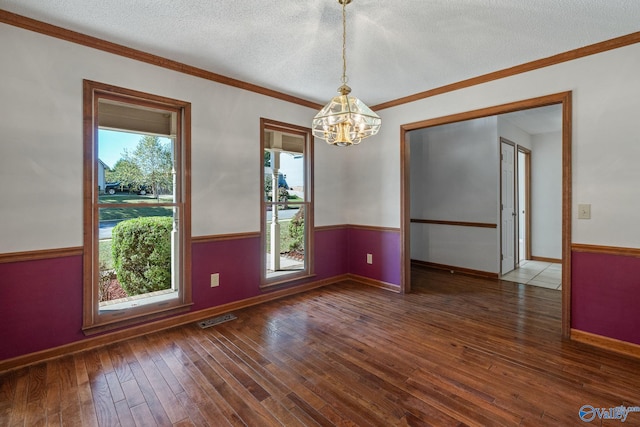 unfurnished room with crown molding, a textured ceiling, a chandelier, and dark hardwood / wood-style floors