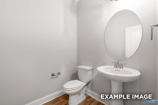 bathroom with hardwood / wood-style floors and toilet