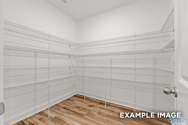 spacious closet featuring hardwood / wood-style flooring