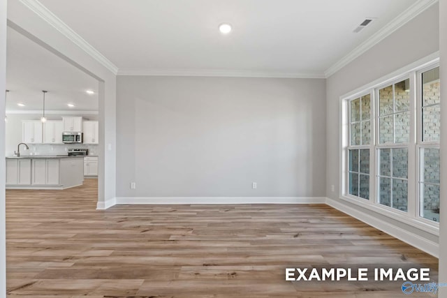 spare room with light hardwood / wood-style flooring and ornamental molding