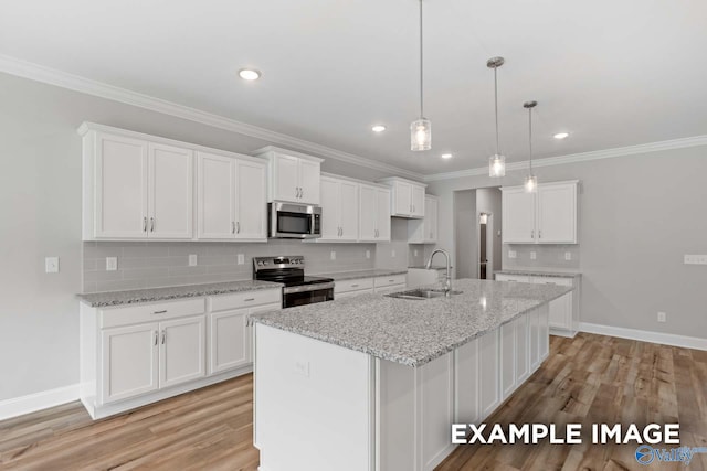 kitchen featuring sink, white cabinets, stainless steel appliances, and a center island with sink