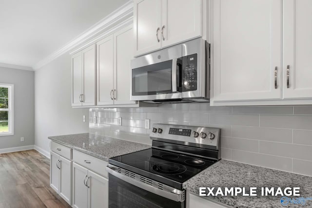 kitchen with light stone counters, white cabinetry, backsplash, and appliances with stainless steel finishes